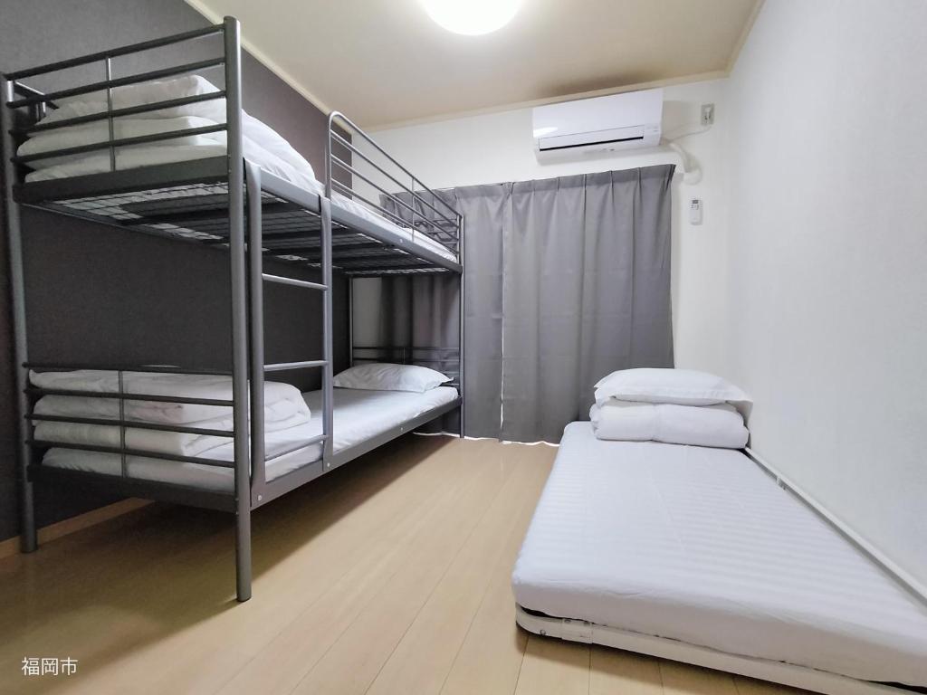 a bedroom with two bunk beds in a room at avanti house大橋A3 in Shiobaru