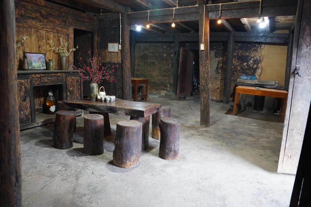 a room with a wooden table and some logs at Hoàng Thông Homestay in Mia Si