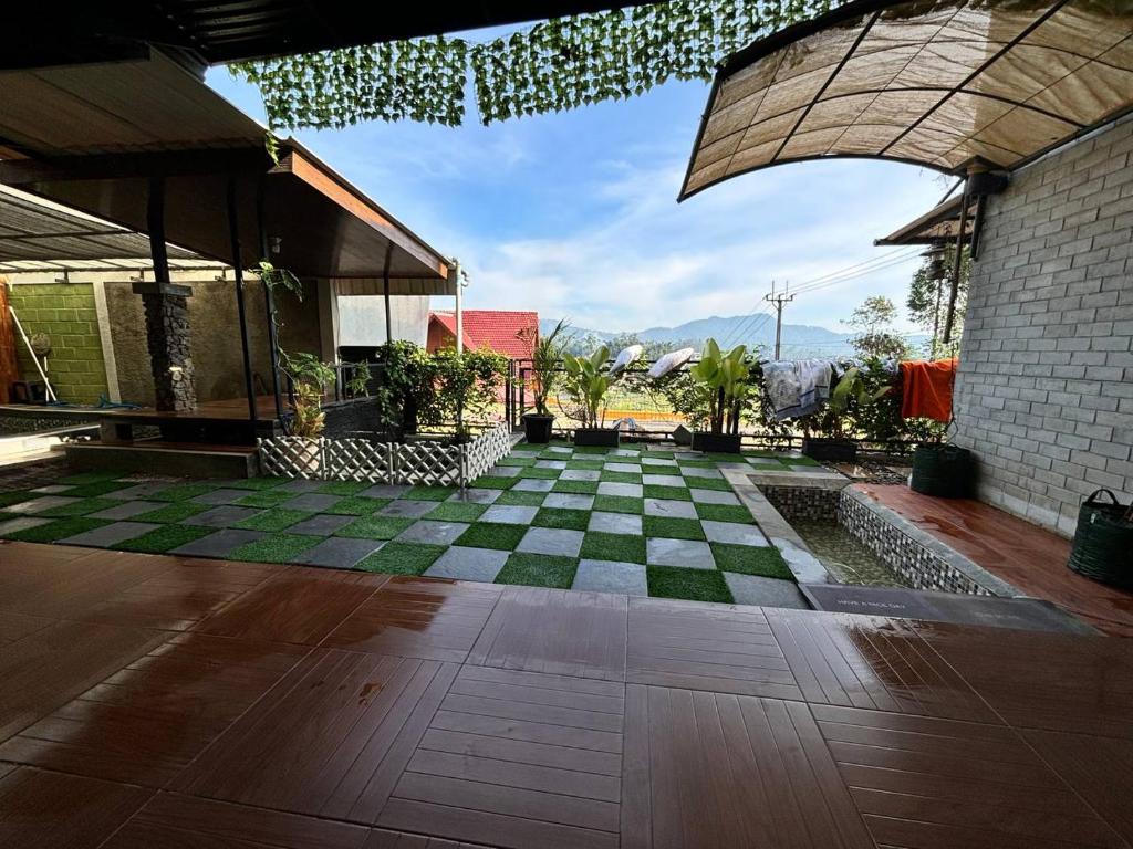 einen Innenhof mit einem karierten Boden und einem Gebäude in der Unterkunft Villa Tagar Hidayah in Ciwidey