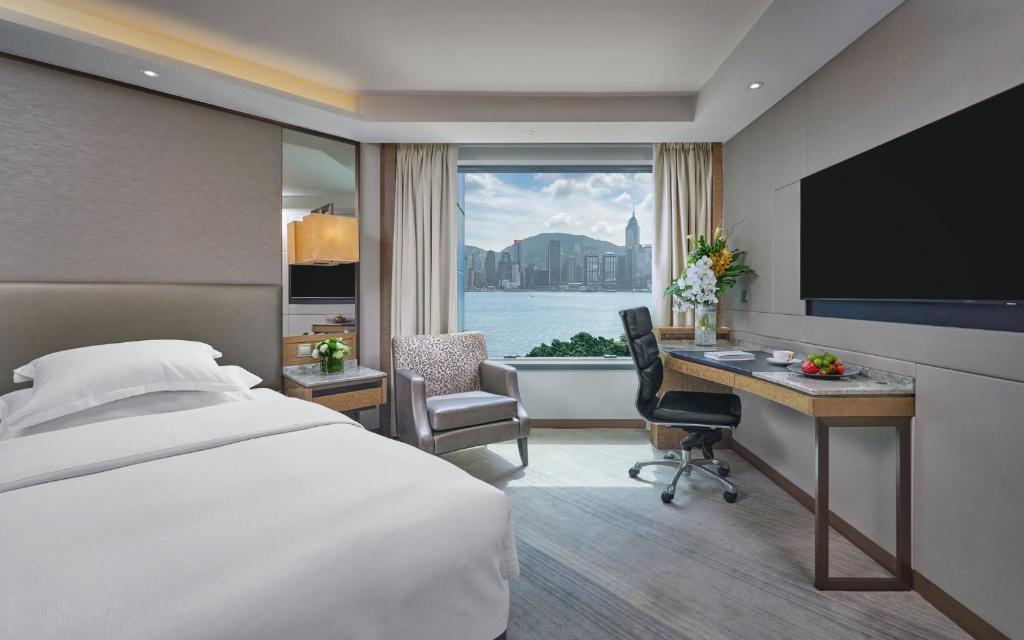 una camera d'albergo con letto, scrivania e TV di InterContinental Grand Stanford Hong Kong by IHG a Hong Kong