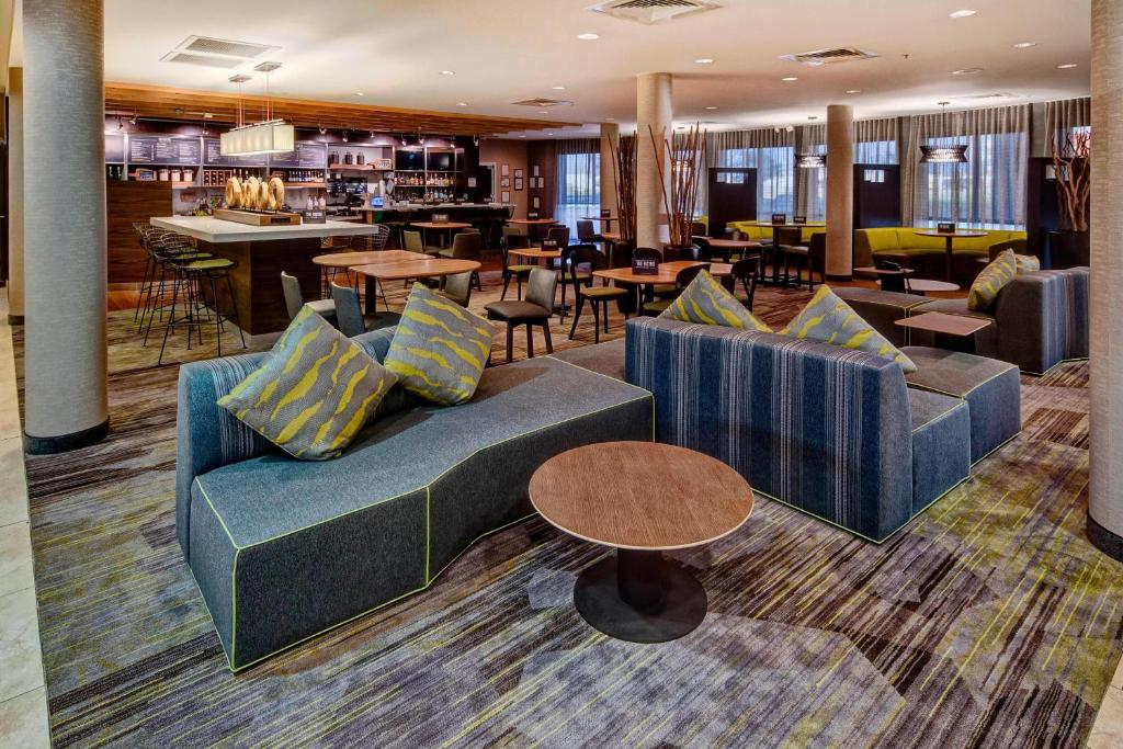 un vestíbulo de hotel con sofás y mesas y un bar en Courtyard by Marriott Alexandria, en Alexandria
