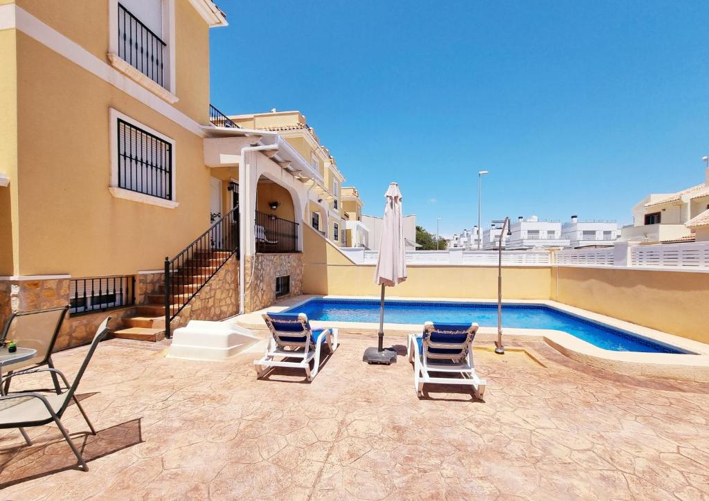 a patio with chairs and a swimming pool at Villa with pool for 10 people in Lo Marab, Ciudad Quesada, Rojales, in Ciudad Quesada