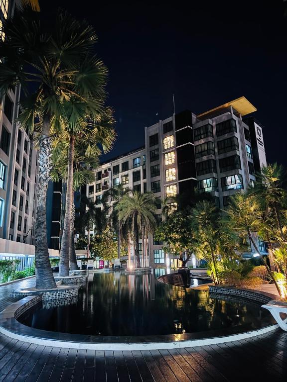 a large fountain in front of a building with palm trees at The private Paradise Two-bedroom condo Only women, shared accommodation in North Pattaya