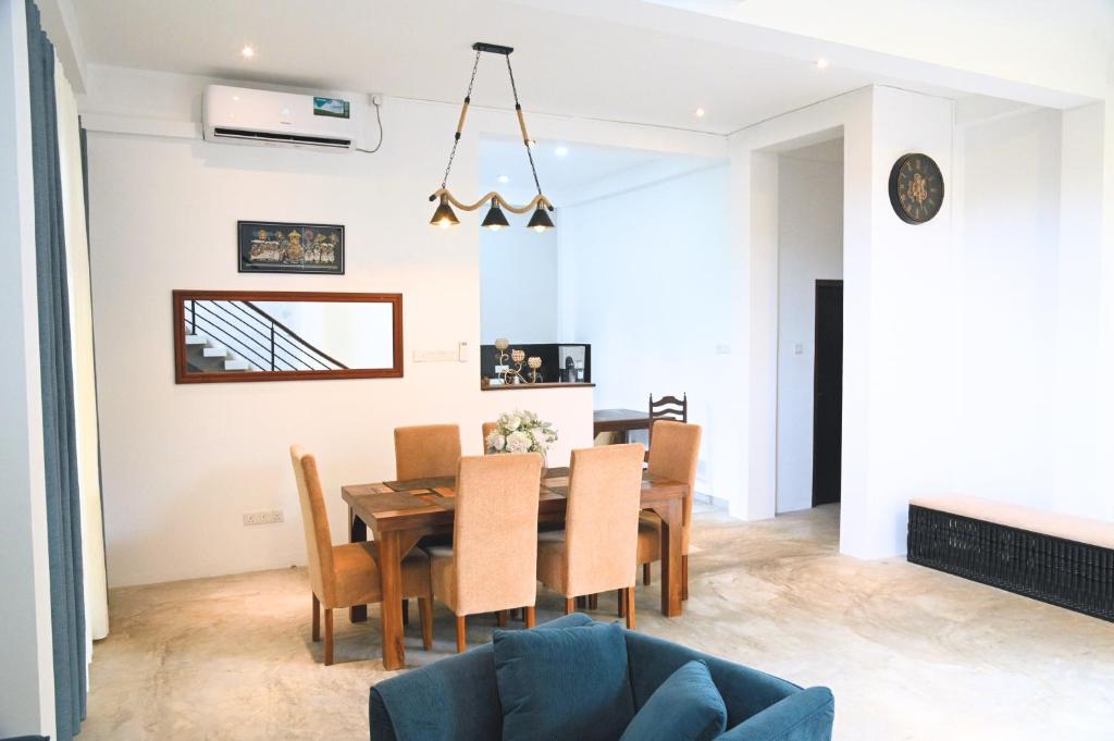 a dining room and living room with a table and chairs at Wind Villa Weligama in Weligama