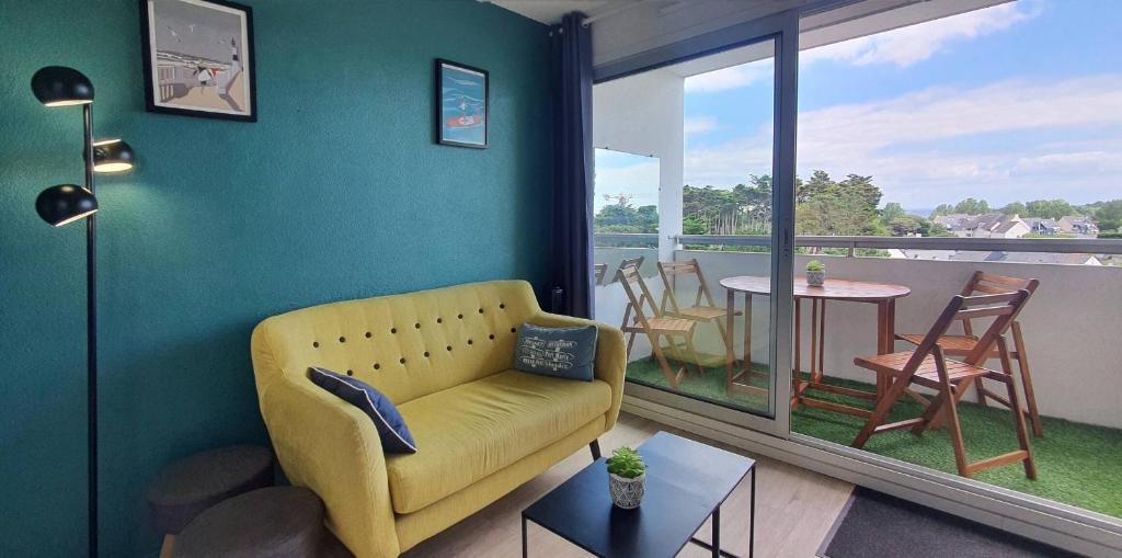 d'un salon avec un canapé jaune et un balcon. dans l'établissement Bleu Horizon, à Quiberon