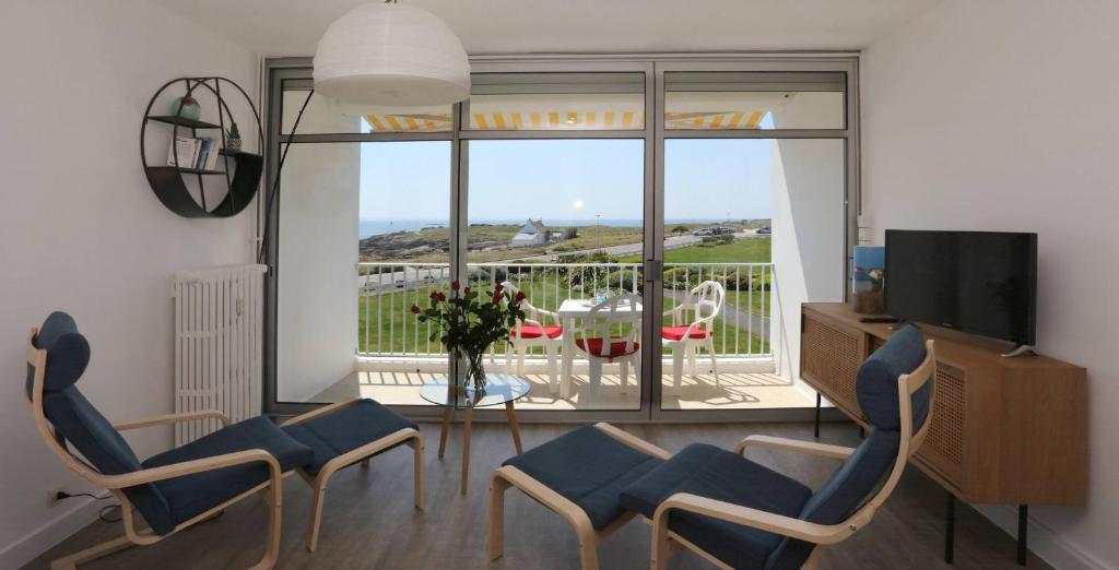 un salon avec une table et des chaises et un balcon dans l'établissement Studio Vue Mer Evasion Marine, à Quiberon
