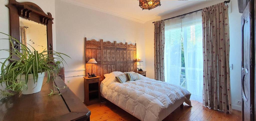 a bedroom with a bed and a large window at La villa les pieds dans leau in Saint-Pierre-Quiberon