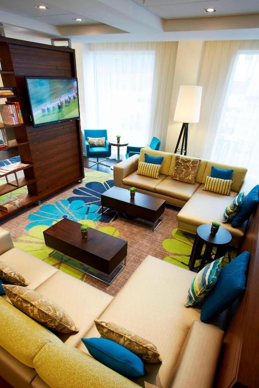 a living room with a couch and a tv at Courtyard by Marriott Aberdeen Airport in Dyce