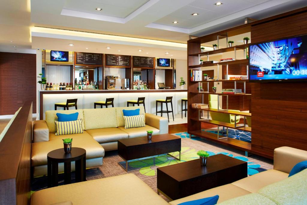 a living room with a couch and a bar at Courtyard by Marriott Aberdeen Airport in Dyce