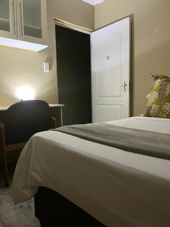 a bedroom with a bed and a white door at Emmanuel-Guest-House in Richards Bay