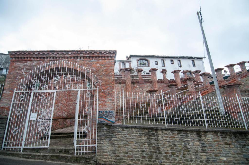 a brick building with a gate in front of it at Castello dei Diamanti in Belvedere Langhe