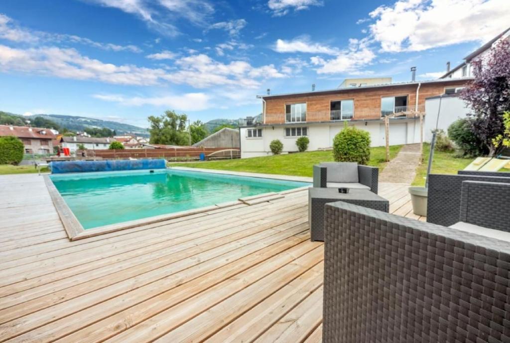einen Pool im Hinterhof mit Holzterrasse in der Unterkunft Maison famille et spa in Cornimont