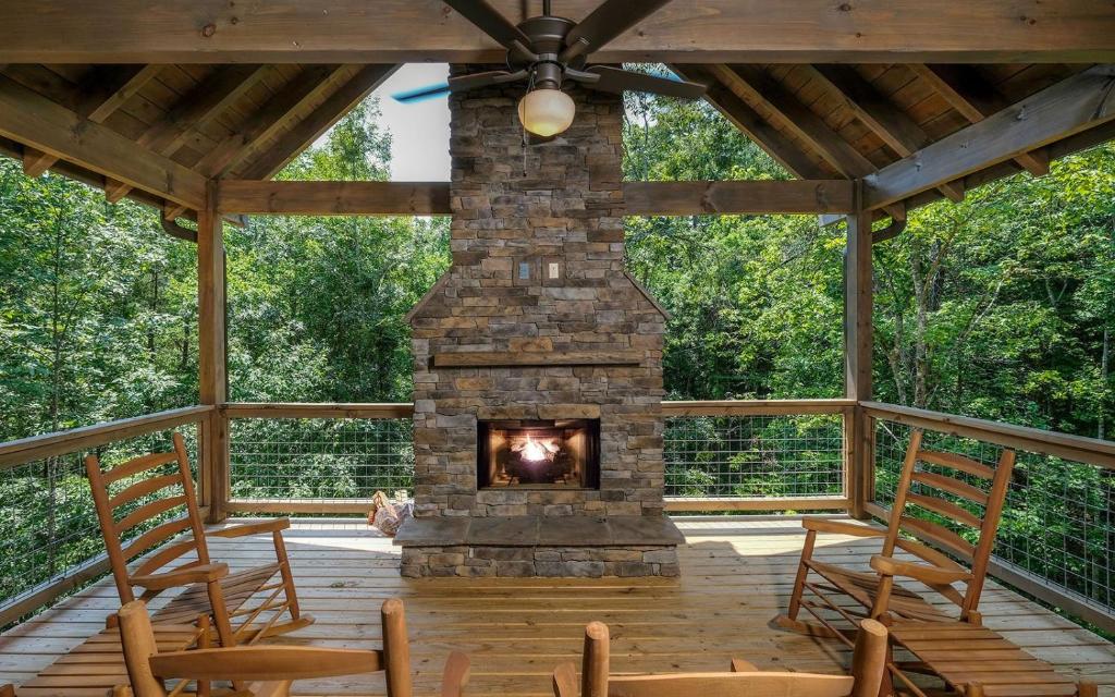 a fireplace on a screened porch with chairs at Rustic Timber in Sevierville