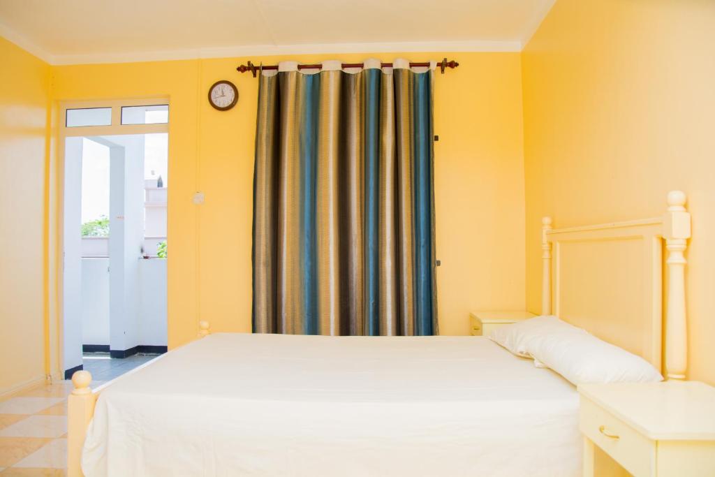 sypialnia z białym łóżkiem i oknem w obiekcie Sunshine Villa w mieście Grand Baie