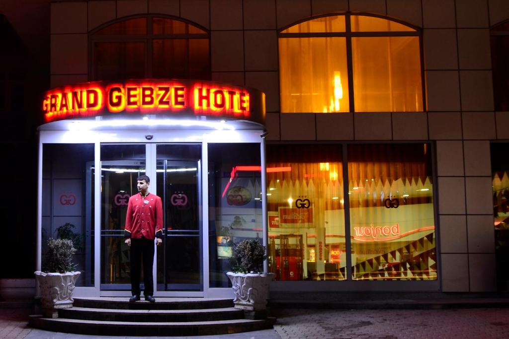 un hombre parado en la puerta de una casa de gansos en Grand Gebze Hotel en Gebze