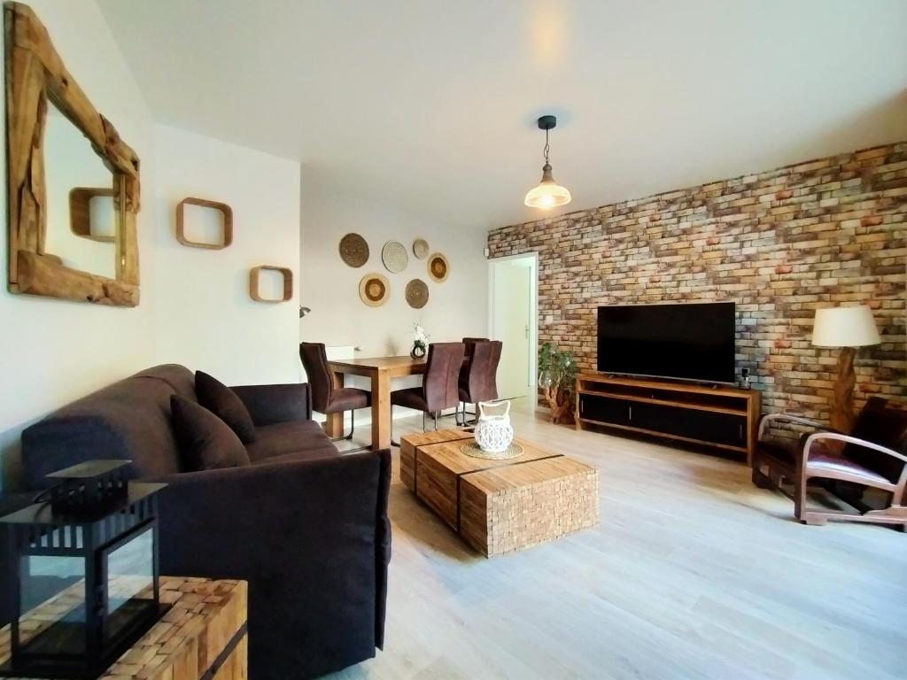 un salon avec un canapé et une table dans l'établissement Chic apart with piano, terrace and parking, à Saint-Denis