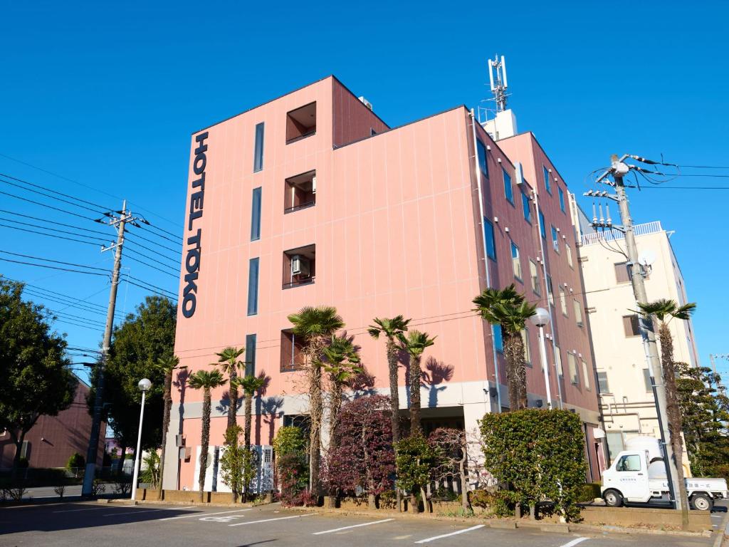 つくば市にあるホテル東光のヤシの木が目の前に広がるピンクの建物