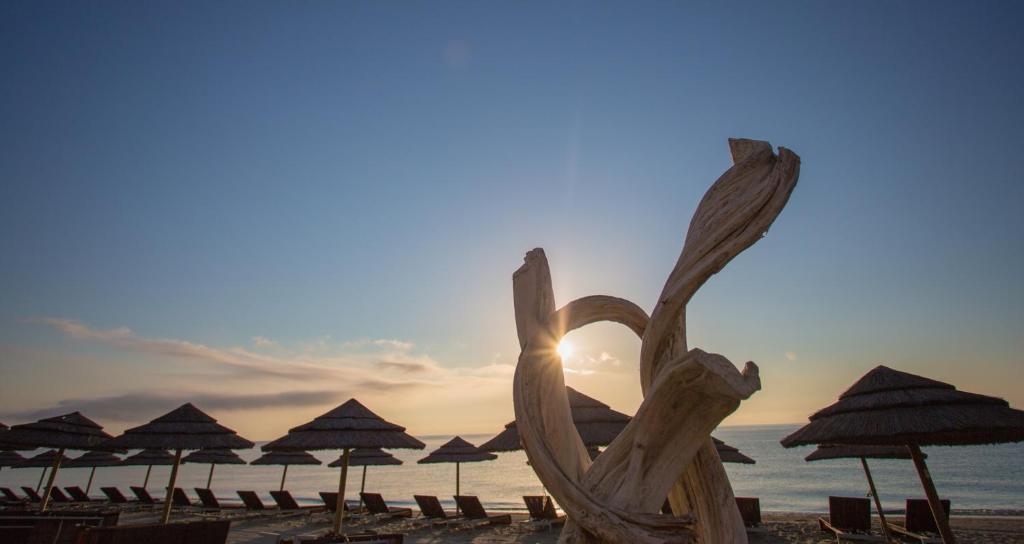 una scultura di cuore su una spiaggia con ombrelloni di Village Vacances La Vallicella a Poggio-Mezzana
