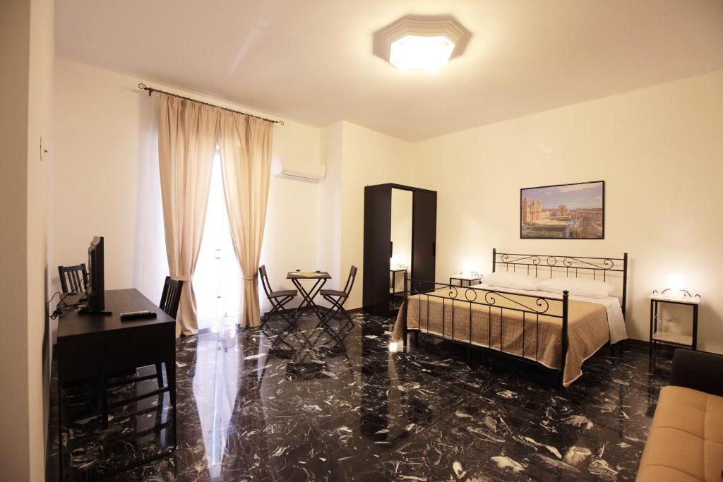 a bedroom with a bed and a desk and a piano at B&B Tarì in Siracusa
