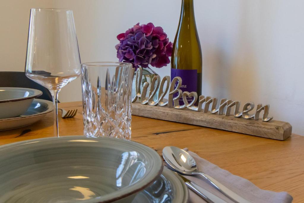 een tafel met een bord en een fles wijn bij Moselhaus Krieger in Traben-Trarbach