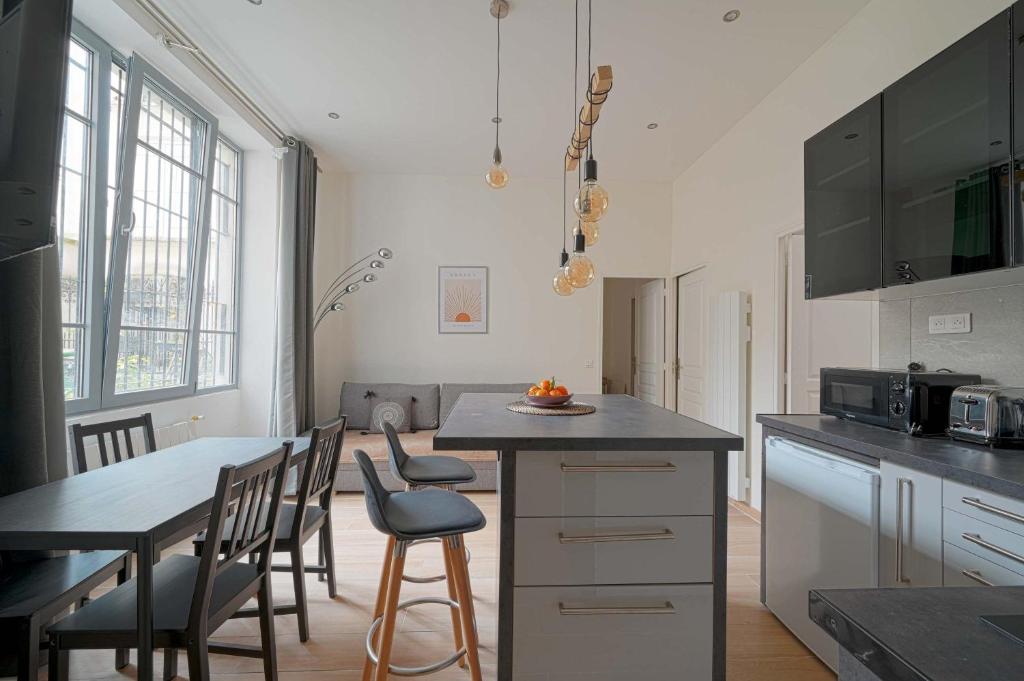 une cuisine avec une table et des chaises et une cuisine avec un comptoir dans l'établissement Bel Appartement Buttes-chaumont, à Paris