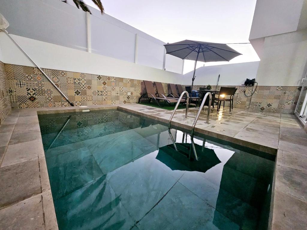 a swimming pool with an umbrella in a house at Villa Blue Moon in Tías