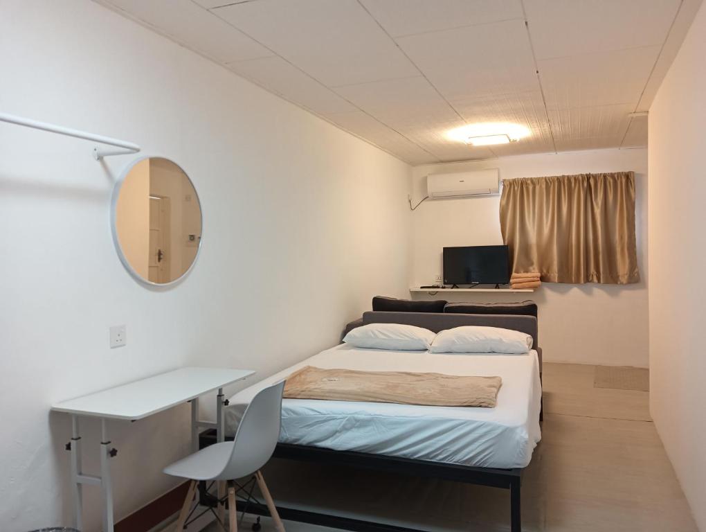 Kleines Zimmer mit einem Bett, einem Schreibtisch und einem Computer. in der Unterkunft HT Home in Ipoh