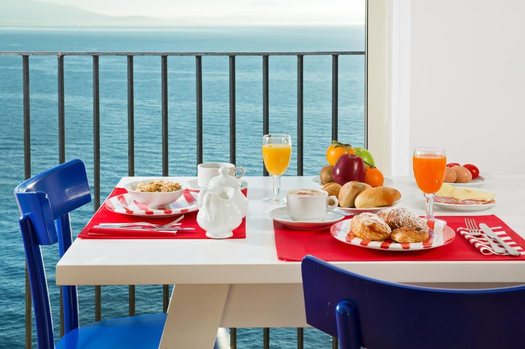 a table with breakfast food on a balcony with the ocean at Hotel Le Terrazze in Conca dei Marini