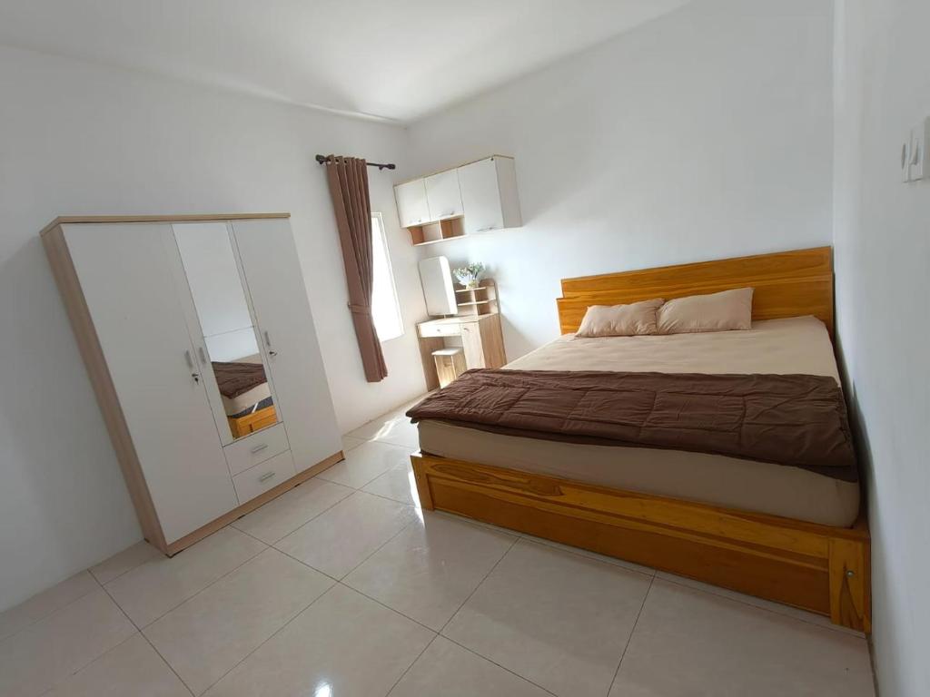 a bedroom with a bed and a large mirror at Villa Aisyahh in Sengkaling