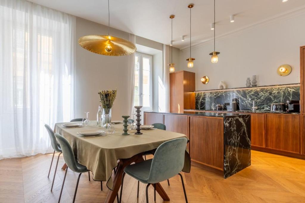 une salle à manger avec une table et des chaises et une cuisine dans l'établissement Casalonga - Prestige Préfecture Comfort - by TGB, à Ajaccio
