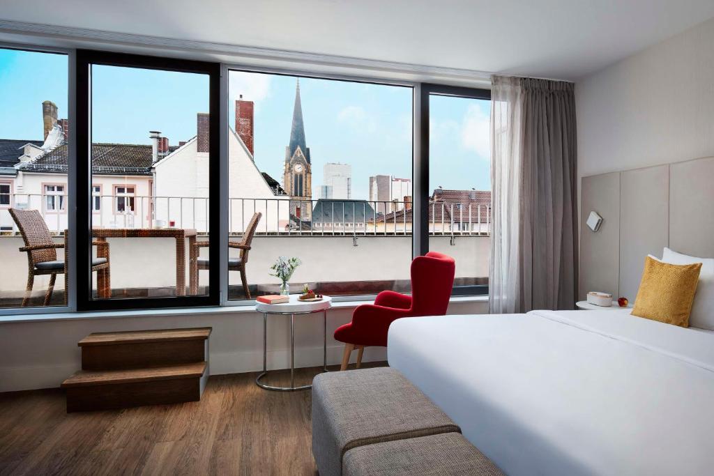 フランクフルト・アム・マインにあるAvani Frankfurt City Hotel - previously NH Collection Frankfurt Cityのベッドと街の景色が見えるホテルの部屋