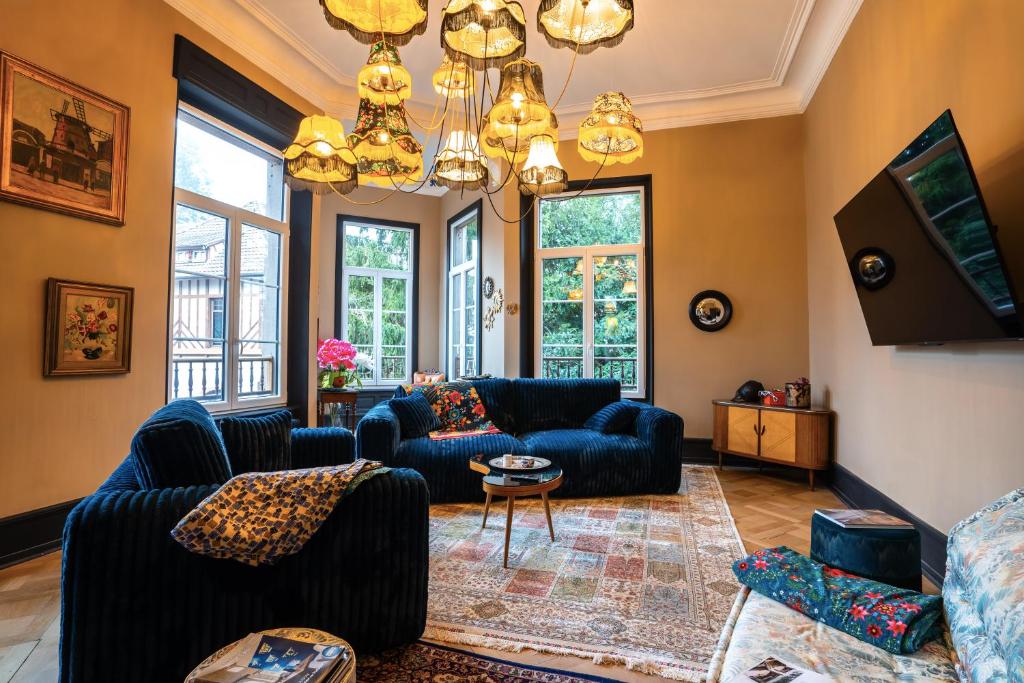 a living room with couches and a chandelier at Domaine Bohème I art de vivre in Guebwiller