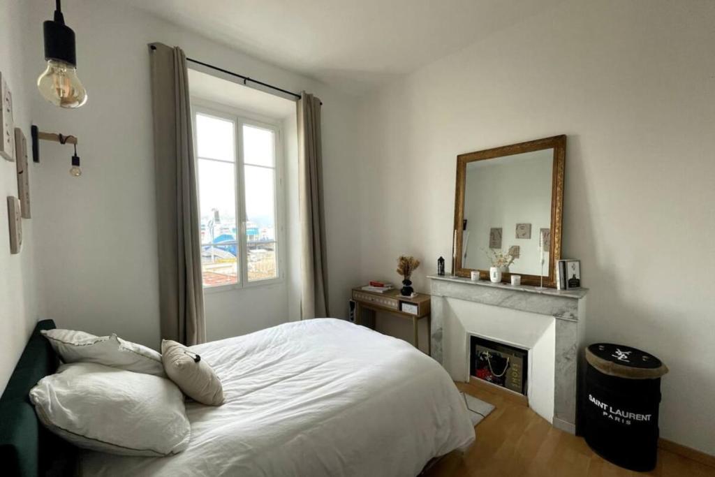 - une chambre avec un lit, un miroir et une cheminée dans l'établissement Jenna - Sea view Cozy City trip - by TGB, à Ajaccio