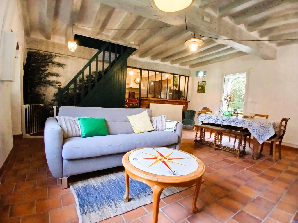 un salon avec un canapé et une table dans l'établissement Domaine d'Ailes - Villa de charme au coeur de la nature avec piscine, à Saint-Florent-sur-Cher