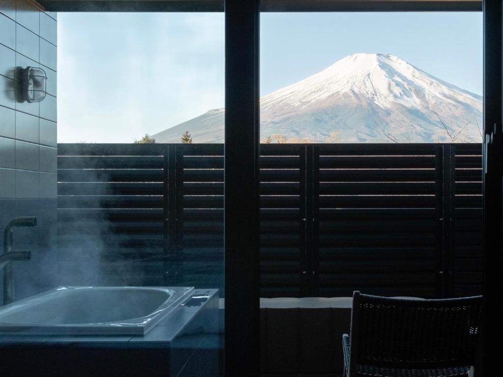 a bathroom with a tub and a mountain view at Mt Fuji View and Private Sauna Ryokan Shizuku in Yamanakako