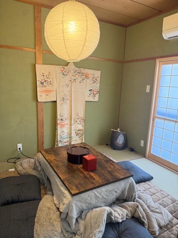 una habitación con una mesa y una lámpara en la pared en 楓の宿 2号館, en Osaka