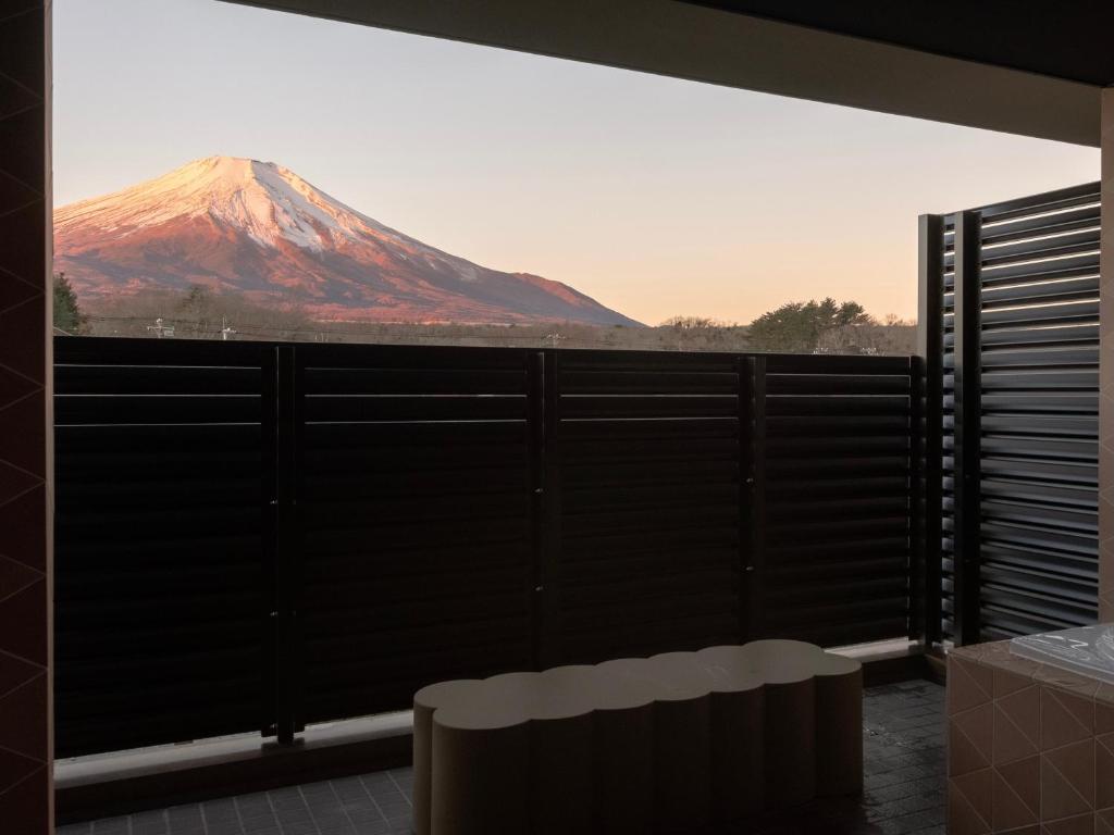 a view of a snow covered mountain from a balcony at Mt Fuji View and Private Sauna Ryokan Shizuku in Yamanakako