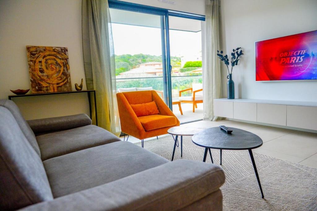 - un salon avec un canapé et une chaise orange dans l'établissement Livia - Agosta beach by foot Terrace - by TGB, à Albitreccia