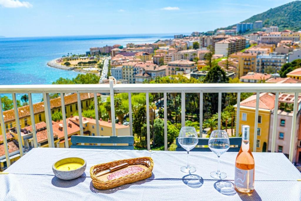 - une table avec des verres et une bouteille de vin sur le balcon dans l'établissement Eugénie - Gorgeous sea view AC WiFi - by TGB, à Ajaccio