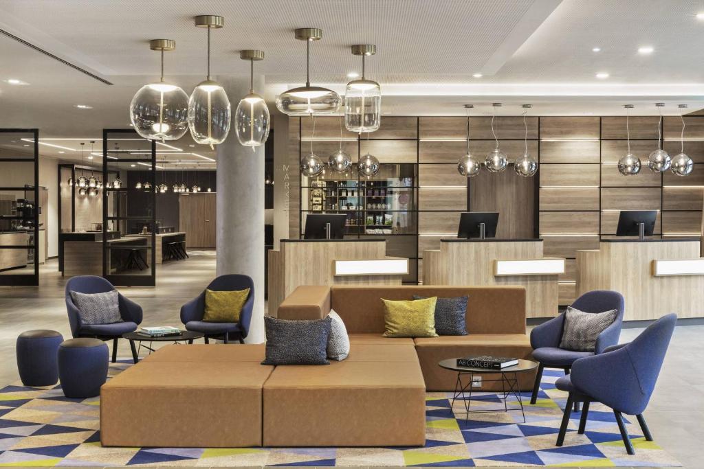 Un vestíbulo de un hotel con un sofá y sillas. en Courtyard by Marriott Hamburg City, en Hamburgo