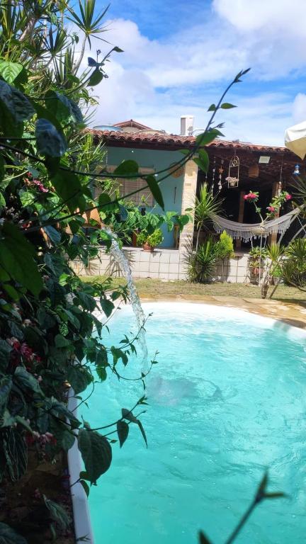 a house with a swimming pool in front of a house at Pousada da Vivi in Maracaipe