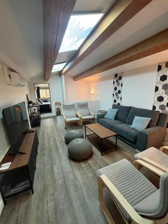 un salon avec un canapé et une télévision dans l'établissement L'Olivier - Joli duplex au cœur du centre ville à 2 pas de la Rotonde Mirabeau et des allées Provençales, à Aix-en-Provence