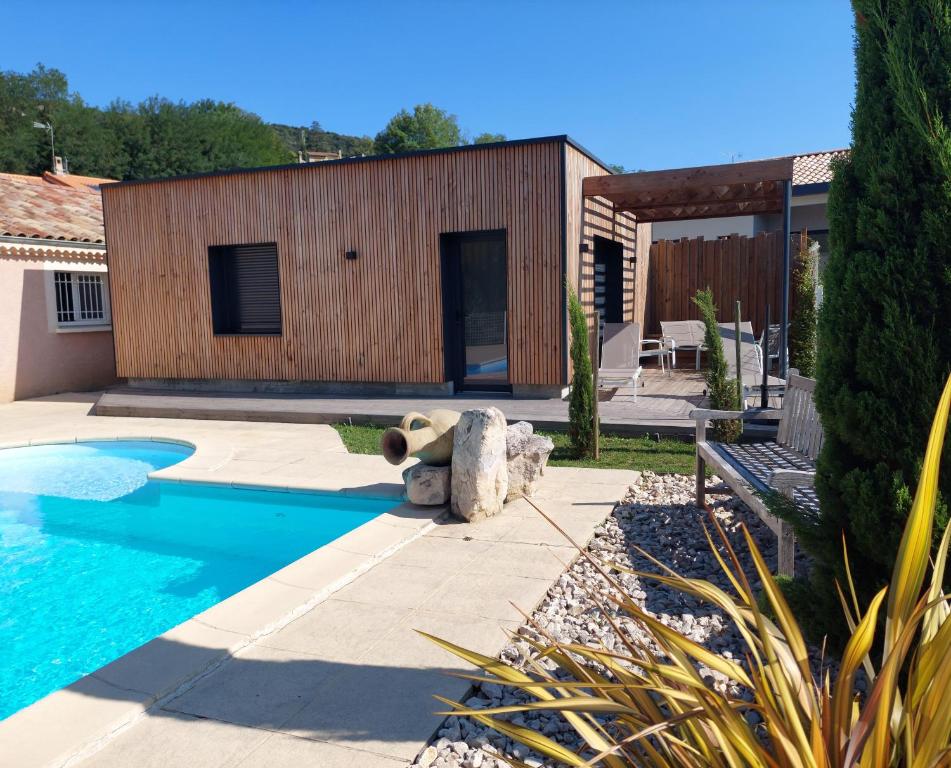 a teddy bear sitting next to a swimming pool at Terre de Crussol - Gite 3 étoiles en Ardèche, avec piscine et clim, 2-4 personnes in Saint-Péray