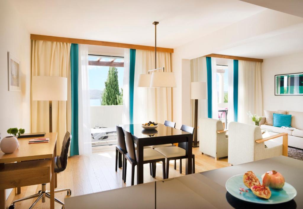 a living room with a table and a dining room at Sun Gardens Dubrovnik in Dubrovnik