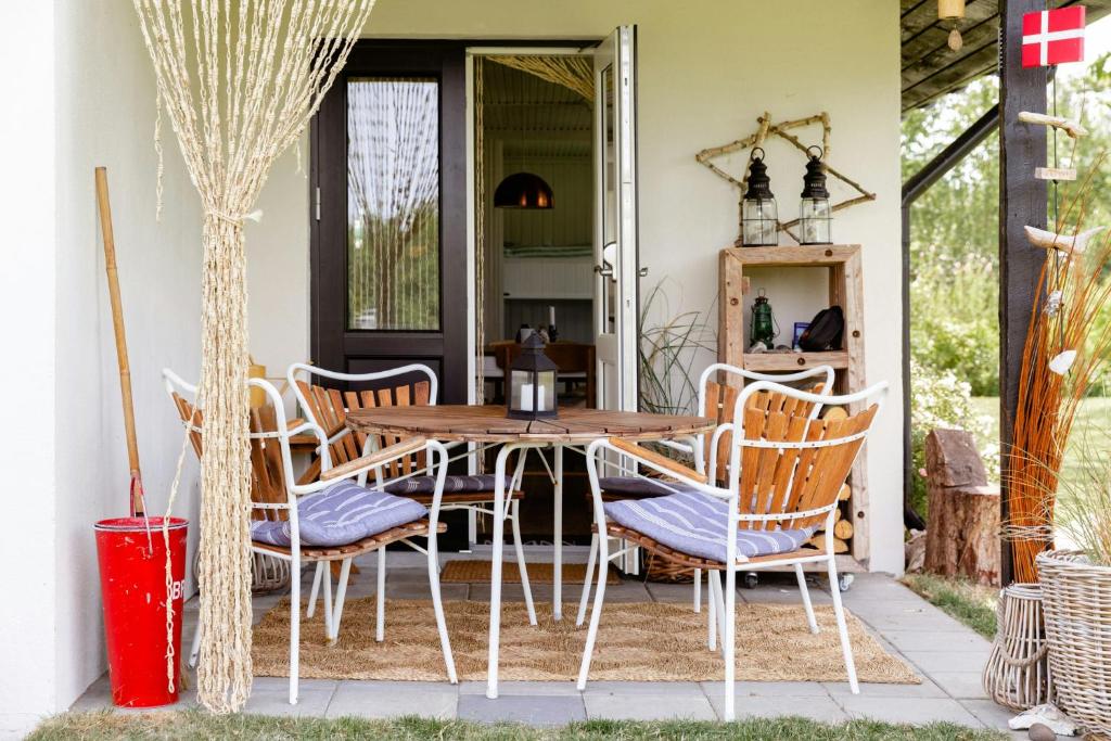 una veranda con tavolo e sedie in legno di Romantic Island Cottage In Cosy Style Near Beach a Maribo