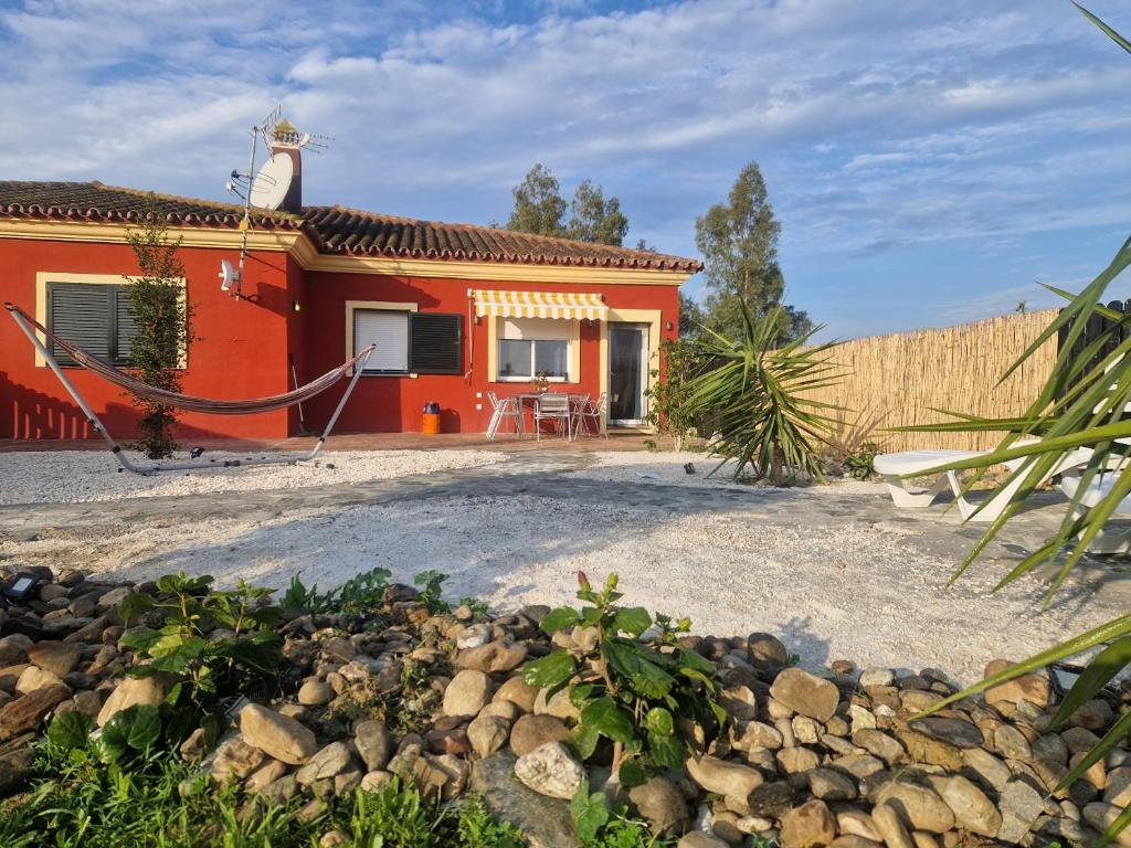 a red house with a yard with a gravel driveway at Casa Anna Rancho Pancho in Alhaurín el Grande
