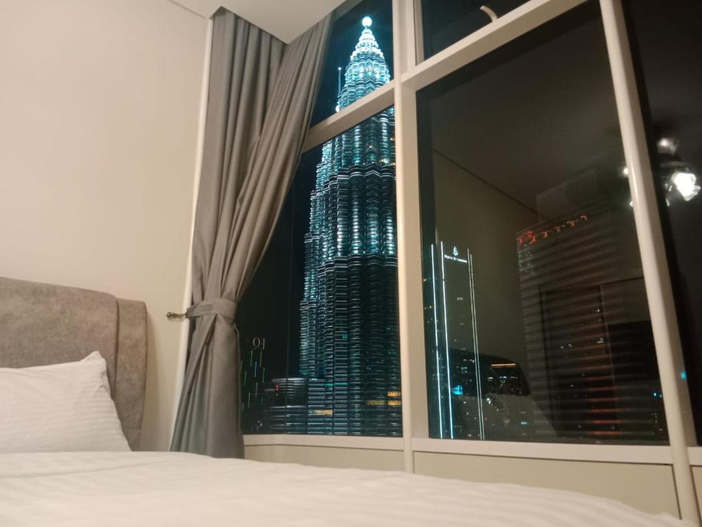a view of the empire state building from a bedroom window at Sky Suites klcc in Kuala Lumpur