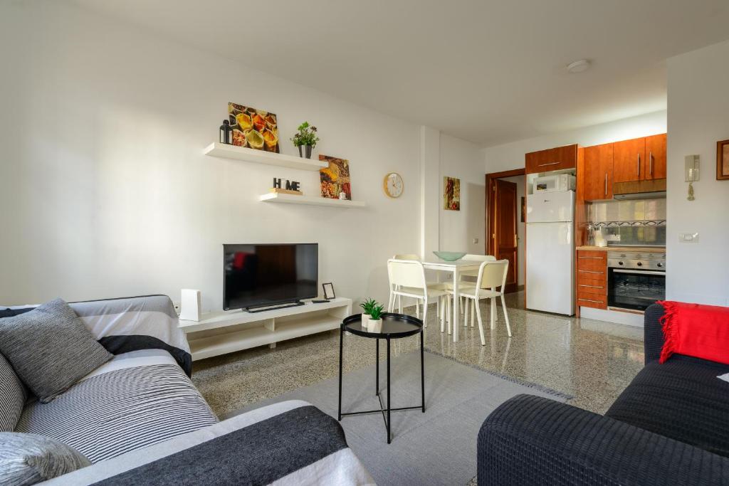 a living room with a couch and a tv and a kitchen at Bonito apartamento en Ingenio in Ingenio