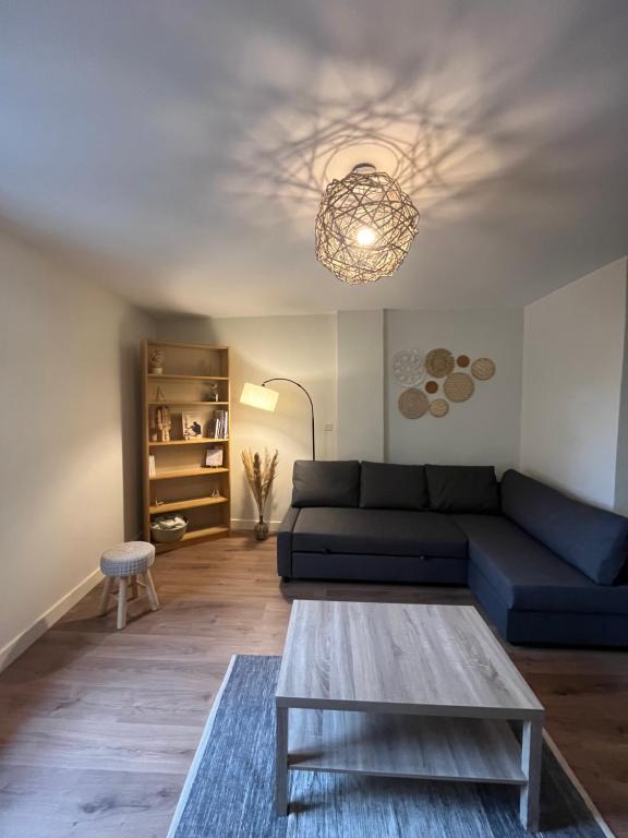 un salon avec un canapé bleu et une table dans l'établissement Joli Duplex Centre Montpellier, à Montpellier
