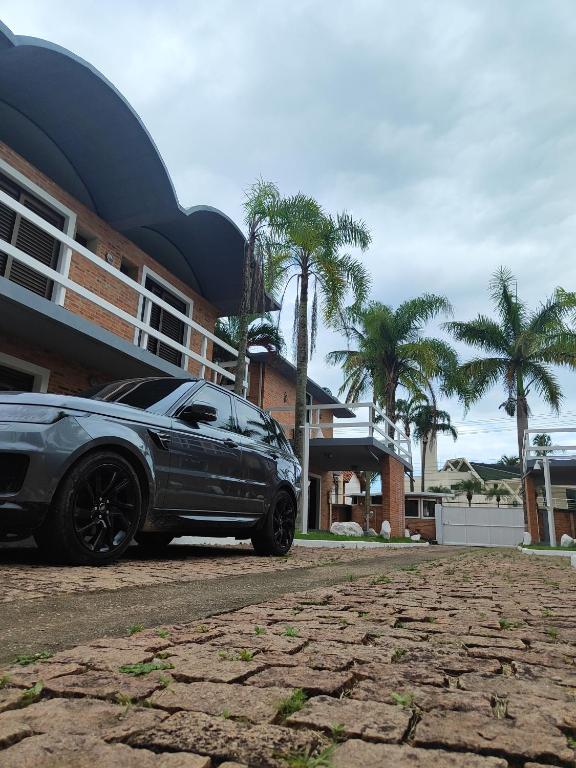 ein schwarzes Auto, das vor einem Gebäude geparkt ist in der Unterkunft Condominio Stoneville in São Sebastião